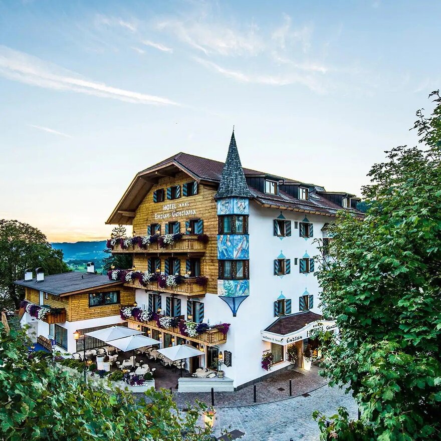 Hotel Enzian Genziana in Seis am Schlern mit blumengeschmückten Balkonen im Abendlicht