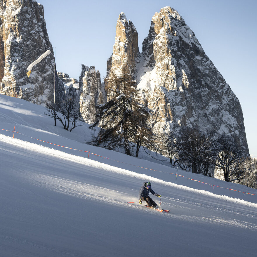 Sciatore sull'Alpe di Siusi con vista sulle guglie rocciose – Hotel Enzian/Genziana